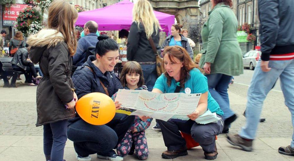 Festival visitors seeking out help from a Festival volunteer last year (pic: John Cudworth)